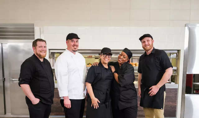 Chefs and cooks smiling in kitchen
