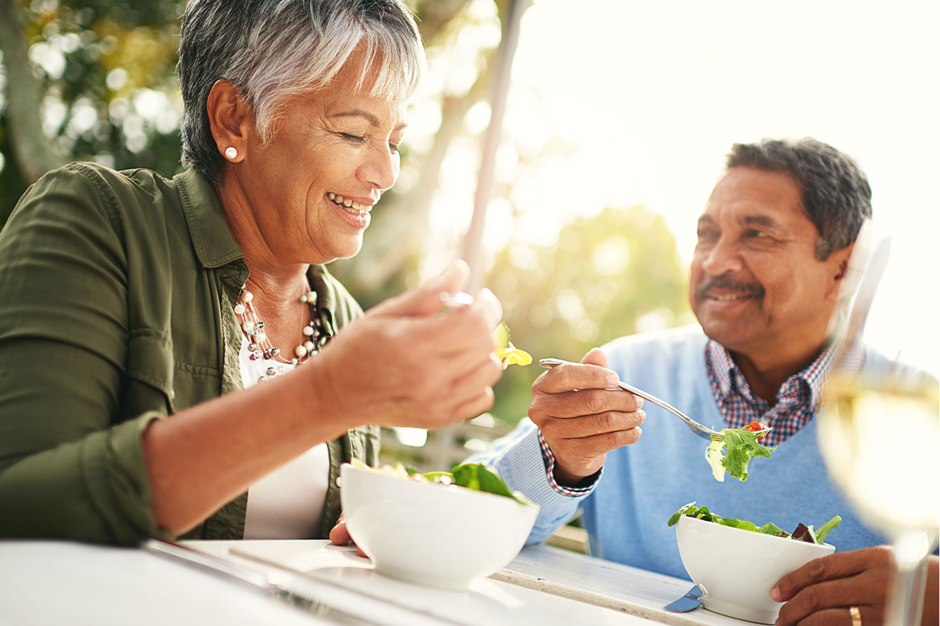 Two adults eating salad