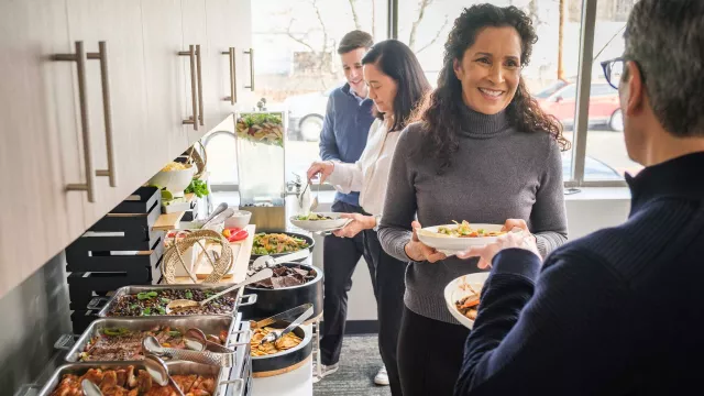 Employees making a plate from buffet