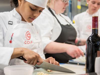 C-CAP student cutting garlic