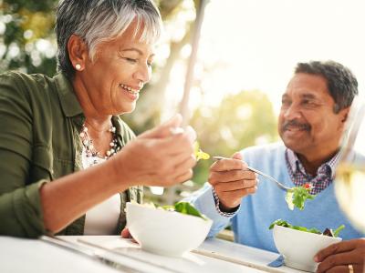 Two adults eating salad