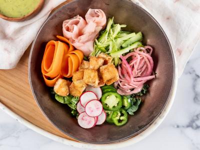 Overhead image of a dish comprised of pickled vegetables and fried tofu in a bowl