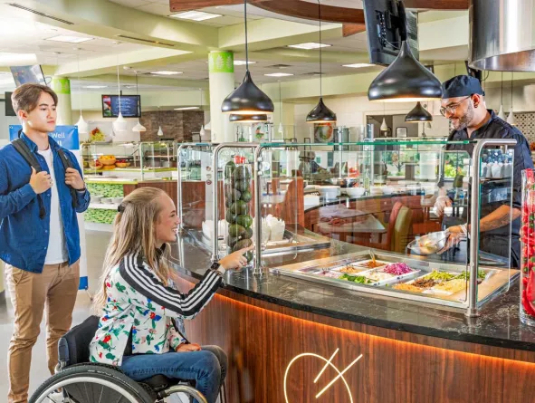 Students in cafeteria line talking to server