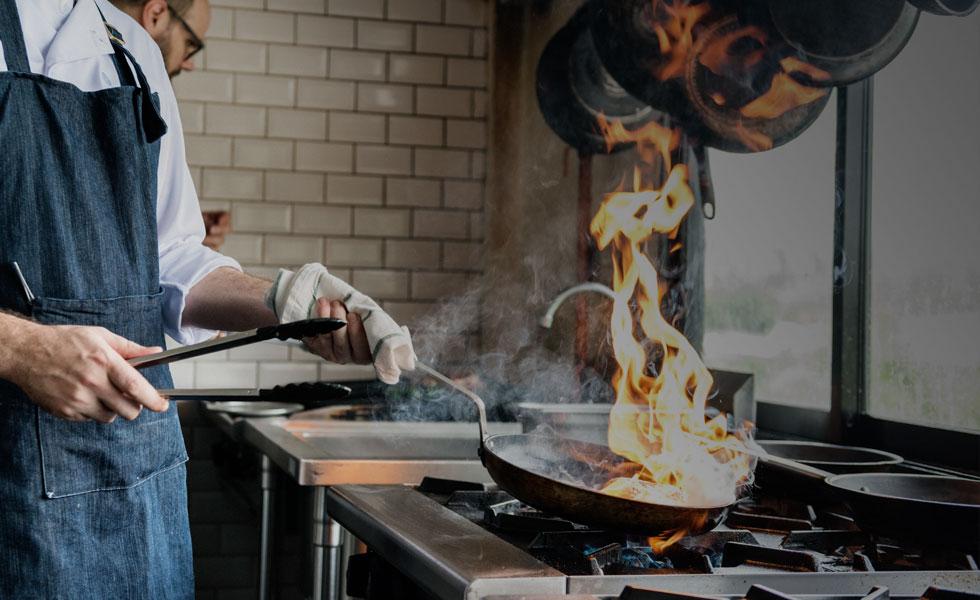 Chef cooking with flames coming from pan