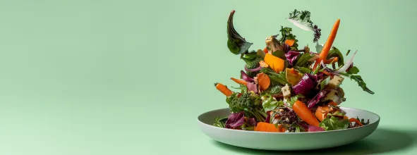 Plate with vegetables falling onto it