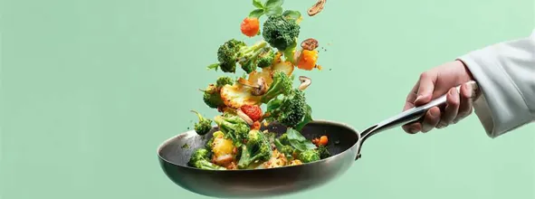 Vegetables being tossed in saute pan