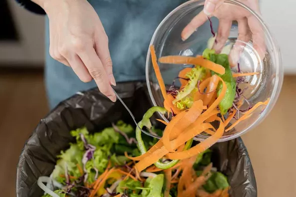 Scraping vegetables scraps into trash